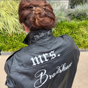 K&ouml;nnte beinhalten: Schwarze Lederjacke mit dem Text "mrs. Bradshaw" und dem Datum "09/20/2023" auf der R&uuml;ckseite gestickt.