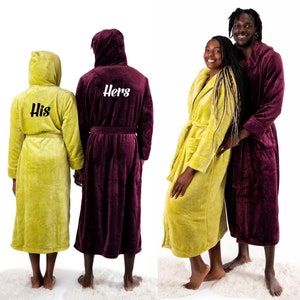 May include: Two plush robes with hoods, one in burgundy and one in yellow, with the words "His" and "Hers" embroidered on the back.