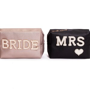 May include: Two cosmetic bags, one gold and one black, with the words "BRIDE" and "MRS" spelled out in pearl-like beads.