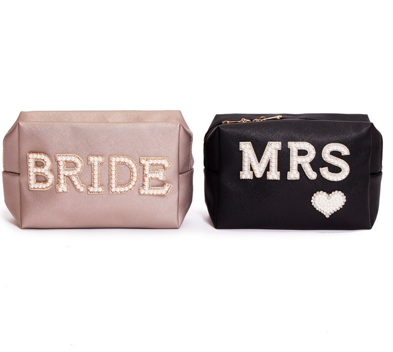 May include: Two cosmetic bags, one gold and one black, with the words "BRIDE" and "MRS" spelled out in pearl-like beads.