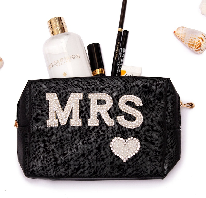 May include: Black zippered makeup bag with a white rhinestone heart and the word "MRS" in white rhinestones.