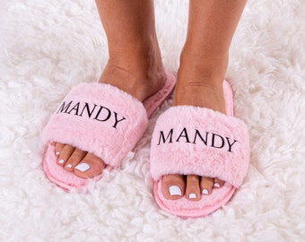 May include: A pair of pink fuzzy slippers with the name "Mandy" embroidered on each one.