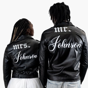 K&ouml;nnte beinhalten: Zwei schwarze Lederjacken mit wei&szlig;em Text auf dem R&uuml;cken. Die Jacke links sagt "mrs. Johnson" und die Jacke rechts sagt "mr. Johnson".