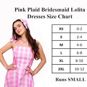 Puede incluir: Un vestido rosa y blanco a cuadros con tirantes finos y un lazo a juego. La imagen incluye una tabla de tallas para los vestidos, que van desde la XS (talla 32-34) hasta la 2XL (talla 42-44). El texto indica que los vestidos tallan peque&ntilde;o.