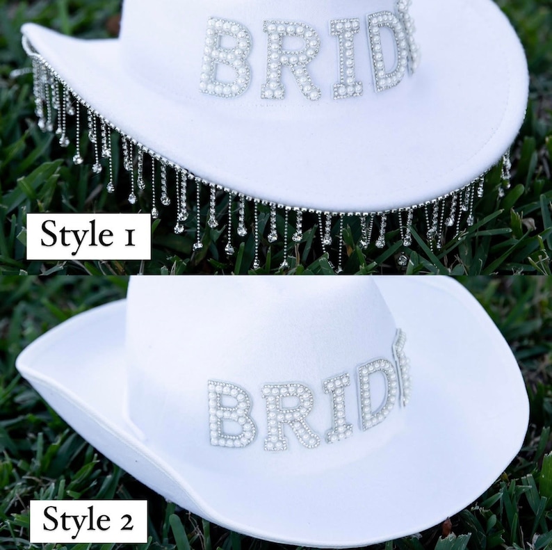 May include: Two white cowboy hats with the word "BRIDE" spelled out in pearl beads. The top hat has a fringe of silver beads hanging from the brim. The bottom hat does not have a fringe.