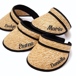 May include: Four straw sun visors with black trim and personalized names: Evelyn, Maria, Emma, and Daniella.