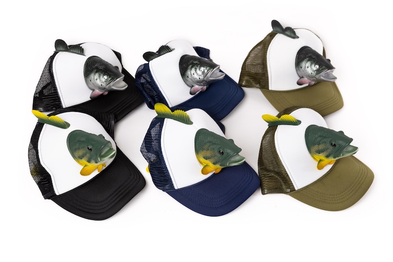 May include: Six different trucker hats with a fish design. The hats are white with a mesh back and come in black, blue, green, and brown.