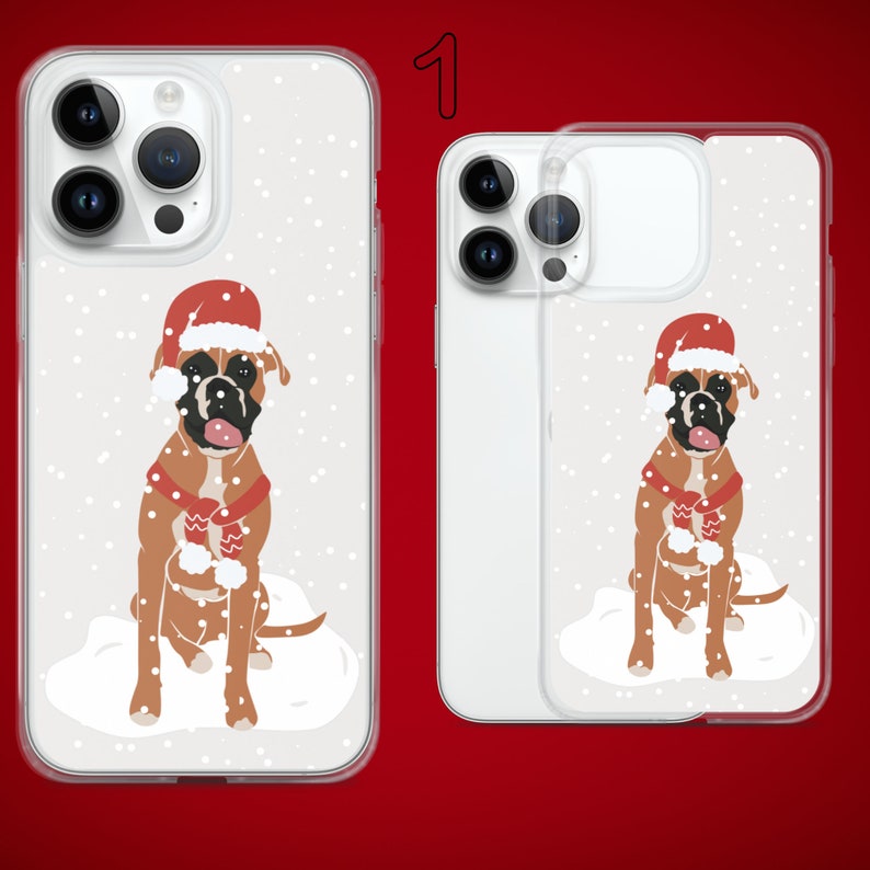 Puede incluir: Dos fundas para tel&eacute;fono con fondo blanco y un dise&ntilde;o de un perro boxer con un gorro de Pap&aacute; Noel y una bufanda roja en una escena nevada. El texto "1" es visible en la esquina superior derecha de la imagen.