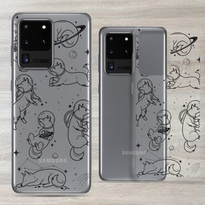 Może przedstawiać: Przezroczyste etui na telefon z czarnym konturem psa w kosmicznym skafandrze i wzorem galaktyki. Etui jest przeznaczone do telefonu Samsung Galaxy S20 Ultra. Etui jest pokazane na szarym telefonie.