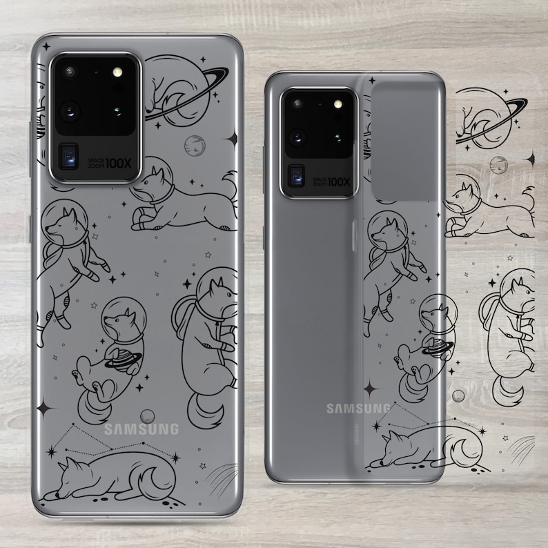 Może przedstawiać: Przezroczyste etui na telefon z czarnym konturem psa w kosmicznym skafandrze i wzorem galaktyki. Etui jest przeznaczone do telefonu Samsung Galaxy S20 Ultra. Etui jest pokazane na szarym telefonie.