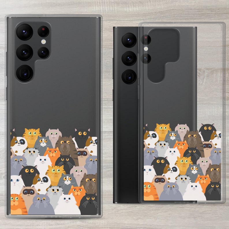 May include: A clear phone case with a black phone inside. The phone case has a design of many colourful cartoon cats on the back. The phone case is designed to fit a Samsung Galaxy S21 Ultra.