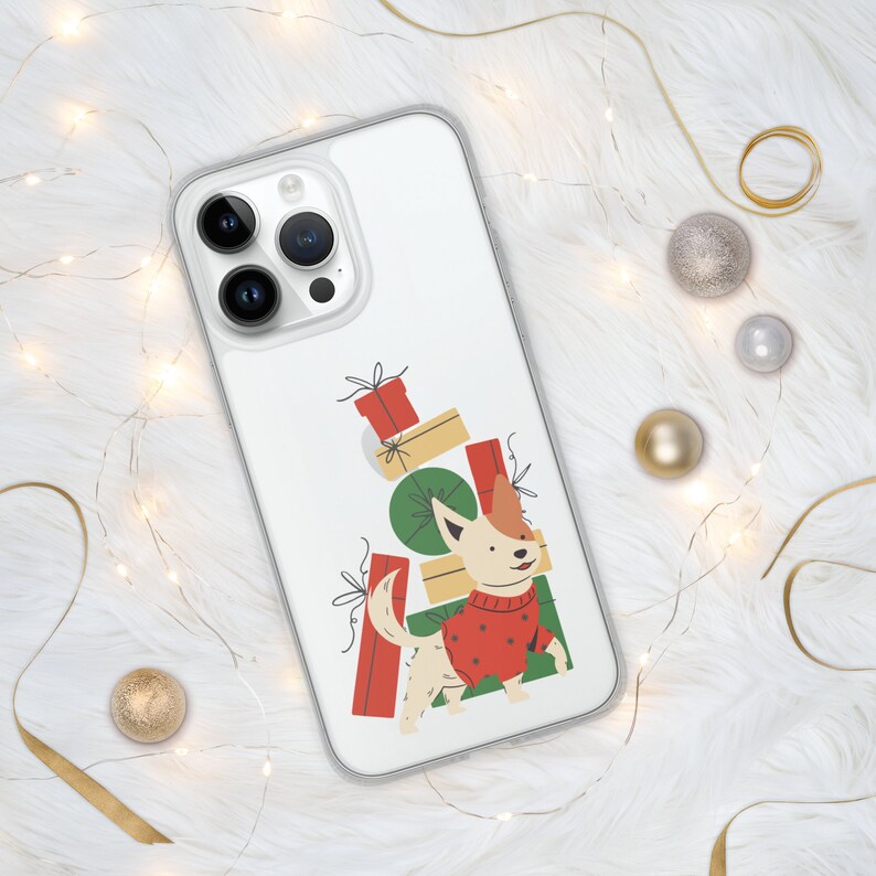 Puede incluir: Una funda de tel&eacute;fono blanca con la parte posterior transparente que presenta un perro de dibujos animados con un su&eacute;ter rojo de pie frente a una pila de regalos con papel de regalo verde y rojo.