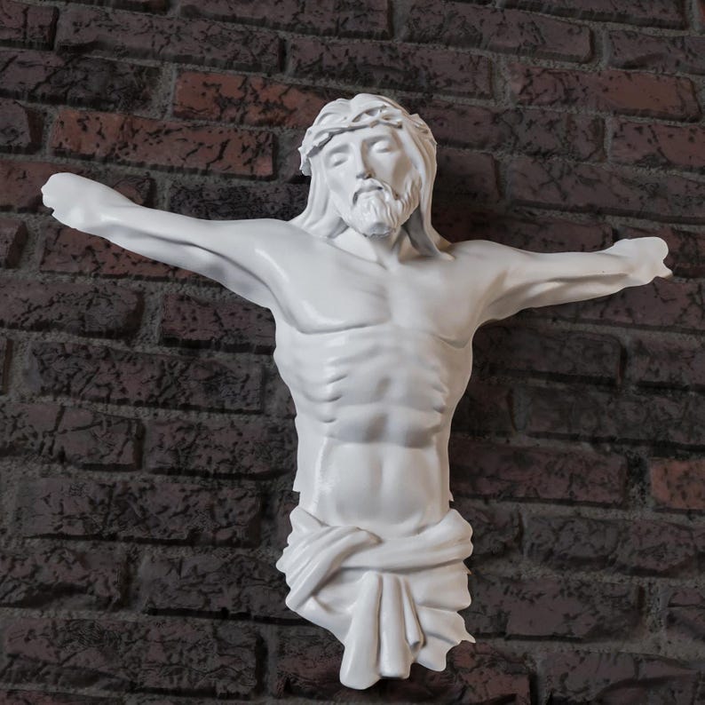 May include: A white sculpture of Jesus Christ on a cross, with arms outstretched. The sculpture has a detailed depiction of the face, hair, and body. The background is a brick wall.