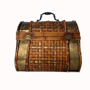 May include: A vintage-style chest with a woven bamboo body, brass accents, and a black handle. The chest features brass-colored metal bands and rivets, with a hinged lid and a decorative clasp. The overall design is reminiscent of a treasure chest.