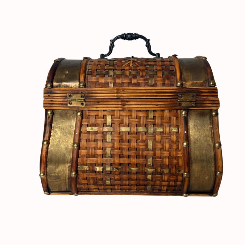 May include: A vintage-style chest with a woven bamboo body, brass accents, and a black handle. The chest features brass-colored metal bands and rivets, with a hinged lid and a decorative clasp. The overall design is reminiscent of a treasure chest.