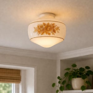 May include: A retro ceiling light with a white, rounded glass shade. The shade is decorated with a floral pattern in yellow and gold, and has a thin gold trim. The light is mounted on a white ceiling.