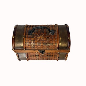 May include: A small, decorative chest with a woven bamboo body, brass-colored metal accents, and a black handle. The chest features a starburst design on the top and is secured with a latch. The overall design is reminiscent of a treasure chest.