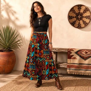 May include: A black short-sleeved crop top paired with a high-waisted, ankle-length skirt featuring a vibrant, multi-colored geometric patchwork pattern in shades of red, orange, yellow, and turquoise, finished with brown leather boots.