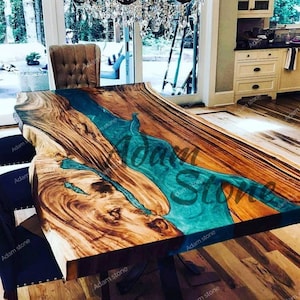 May include: A large wooden table with a live edge and a turquoise blue epoxy river running through the center. The table is made of natural wood and has a rustic, organic look.