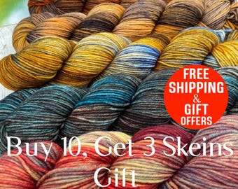 May include: A collection of hand-dyed yarn skeins arranged in rows, featuring a variegated color palette of warm oranges, deep browns, golden yellows, muted blues, and rich reds, with a textured, twisted fiber construction.