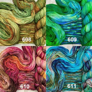 May include: Four skeins of hand-dyed yarn with matching knitted swatches, labelled 608 in olive and gold, 609 in emerald and blue, 610 in magenta and orange, and 611 in teal and navy. Each set displays variegated colour patterns.