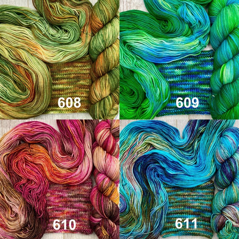 May include: Four skeins of hand-dyed yarn with matching knitted swatches, labelled 608 in olive and gold, 609 in emerald and blue, 610 in magenta and orange, and 611 in teal and navy. Each set displays variegated colour patterns.