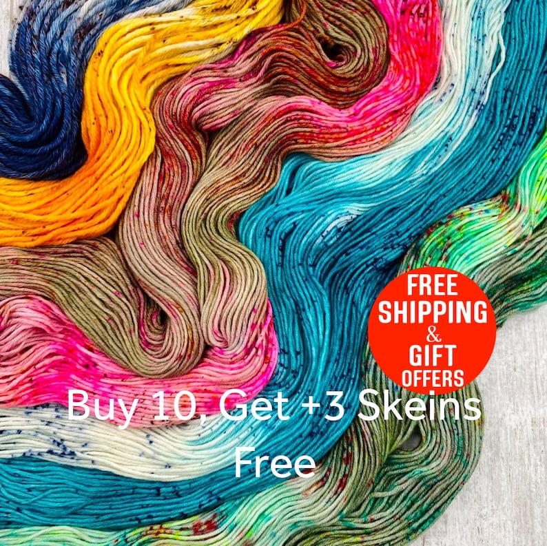 May include: A collection of multi-coloured yarn skeins arranged in a flowing, overlapping pattern. The colours include deep blue, bright yellow, warm brown, vibrant pink, white, turquoise, and light green, all featuring speckled accents.