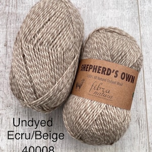 May include: Two skeins of Shepherd's Own 100% all natural undyed wool yarn in an ecru and beige colorway. The yarn features a twisted ply construction. A brown paper label on one skein displays the text Shepherd's Own, 100% All Natural Undyed Wool.