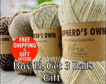 May include: A row of four balls of Shepherd's Own 100% all natural undyed wool yarn by Fibra Natura. The yarn balls range in colour from dark brown and white speckled to light cream, each wrapped in a brown paper label with black text.