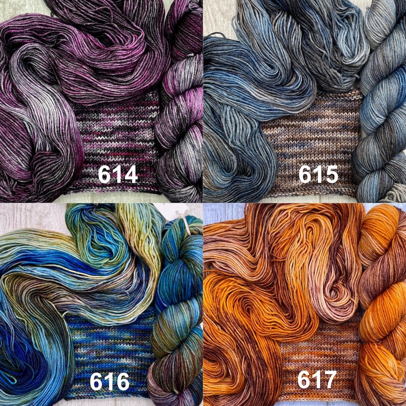 May include: Four skeins of hand-dyed yarn with matching knitted swatches, labelled 614 in purple and black, 615 in blue and grey, 616 in blue and green, and 617 in orange and brown, each displaying unique variegated colour patterns.