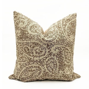 May include: A beige and brown patterned throw pillow with a paisley design.