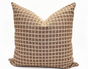 May include: A brown and beige patterned throw pillow with a square grid design.