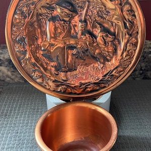 May include: A copper wall mounted planter with a relief design of a hunter with a dog in a forest setting.
