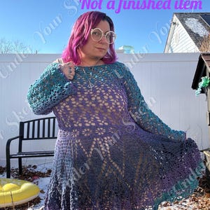 May include: A crochet pattern for a dress with long sleeves. The dress transitions from teal to purple, with a floral pattern on the bodice. The text "Crochet Pattern" and "Not a finished item" are visible.