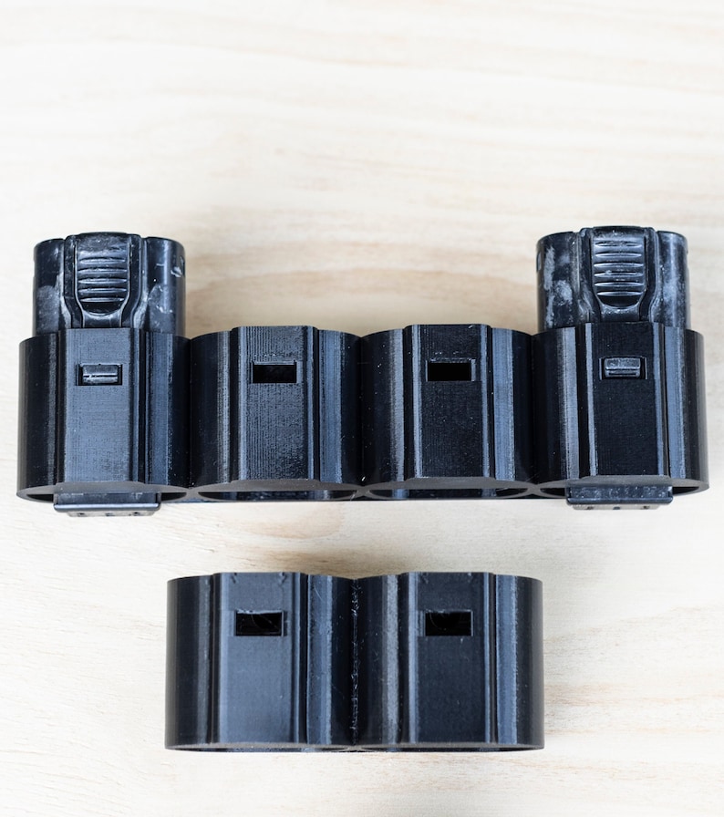 K&ouml;nnte beinhalten: Schwarzer Batteriehalter aus Kunststoff mit sechs Steckpl&auml;tzen f&uuml;r Batterien. Der Halter ist in zwei Abschnitte unterteilt, einen mit zwei Steckpl&auml;tzen und den anderen mit vier Steckpl&auml;tzen.
