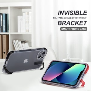 May include: Clear smart phone cases with built-in brackets. One case has a black bracket, the other has a red bracket. The cases are on a white surface. The text on the image reads: INVISIBLE, MILITARY-GRADE DROP-PROOF, BRACKET, SMART PHONE CASE.