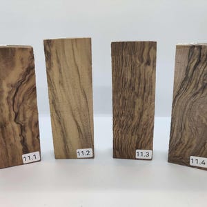 Op de afbeelding: Vier stukken hout met een uniek nerfpatroon. Het hout is lichtbruin met donkerbruine strepen. De stukken zijn gelabeld 11.1, 11.2, 11.3 en 11.4.