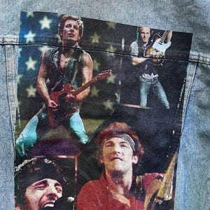 May include: Light blue denim jacket featuring a multi-image graphic of a musician playing guitar. The graphic includes images of the musician in different poses. A small leather patch with the letters "BX" is on the bottom.
