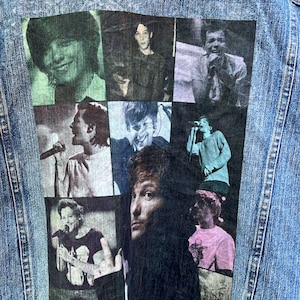 May include: A denim jacket with a collage of images of a band printed on the back. The images are in black and white and show the band members in various poses.