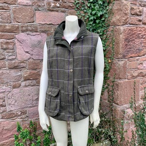 May include: A green and purple checked waistcoat with a zip fastening and two front pockets.