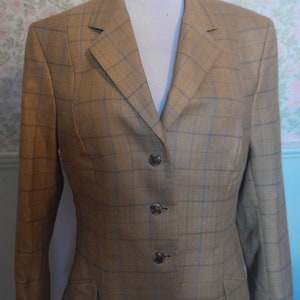 May include: A brown blazer with a subtle plaid pattern and four button fastenings. The blazer has a classic, tailored fit.