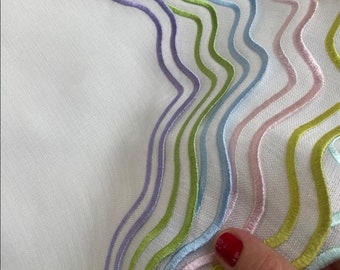 May include: White fabric with a wavy pattern of embroidered lines in shades of green, blue, pink, and purple.