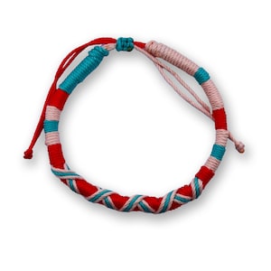 May include: A red, white, and turquoise braided friendship bracelet. The bracelet is made of woven string and has a knot at the end.
