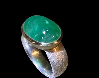 Large emerald cabochon in silver ring with gold-plated setting