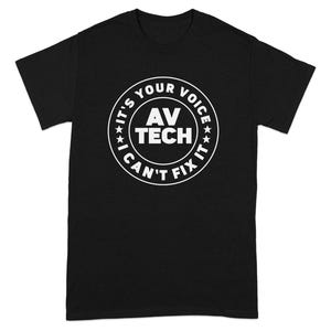 May include: Black t-shirt with a white circular graphic. The graphic reads "AV TECH" in the center, surrounded by "IT'S YOUR VOICE I CAN'T FIX IT" in a circular pattern. The design includes small star accents.