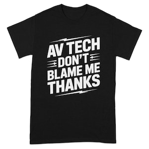 May include: Black t-shirt with the white text "AV TECH DON'T BLAME ME THANKS". The text is in a bold, stylized font. The shirt is a crew neck style.