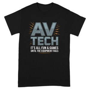 May include: Black t-shirt with the text "AV TECH" in gray and white, with lightning bolt accents. Below the text is the phrase "IT'S ALL FUN & GAMES UNTIL THE EQUIPMENT FAILS".