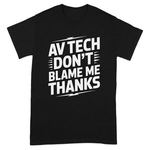 May include: Black t-shirt with the white text "AV TECH DON'T BLAME ME THANKS". The text is in a bold, sans-serif font, with a lightning bolt graphic. The shirt is a short-sleeved crew neck.