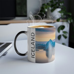 May include: White ceramic mug with a black handle. The mug has a heat-sensitive design that reveals a picture of an icy landscape with the word "ICELAND" on the side when hot liquid is poured into the mug.
