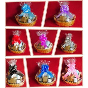 May include: Nine wicker baskets filled with various bath and body products, each wrapped in clear cellophane and tied with a different colored satin ribbon bow. The bows are black, blue, pink, purple, red, silver, and light blue.